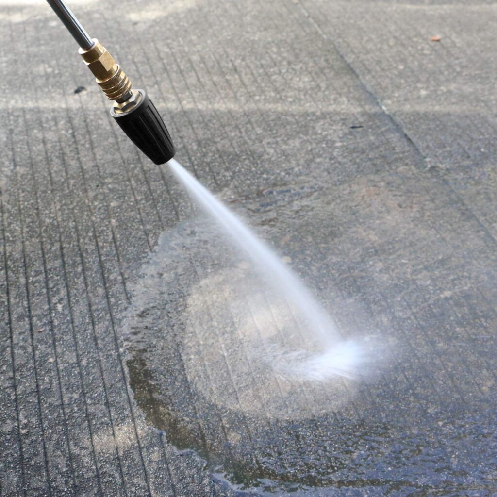 Hose pressure washes pavement